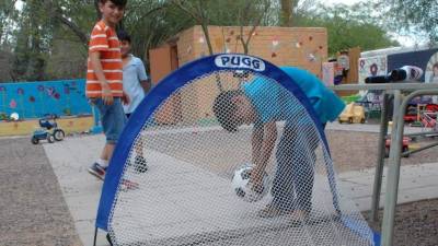 Un grupo de niños jugando fútbol en el patio del albergue en Tucson, Arizona. Foto de archivo.