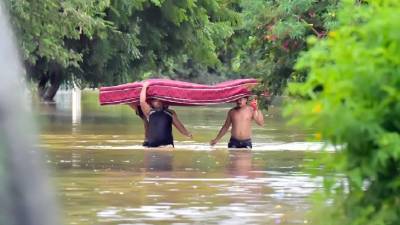 Con el agua a la cintura, pobladores de El Progreso salieron de las zonas anegadas por el Ulúa. EFE/ José Valle