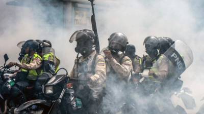 Policías antidisturbios intentan controlar una revuelta de la oposición en Caracas, Venezuela.