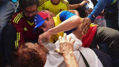 El líder opositor, Henrique Capriles, asiste a una persona herida durante las manifestaciones en Caracas.