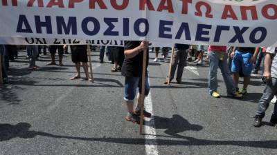 Workers at the large state-run mining and metallurgical company LARKO hold a banner reading ' Larko under state control' during a rally in central Athens on August 28, 2013 against the privatisation of the company. Having paid the price with six years of recession and draconian austerity, Greece now still faces a 10-billion-euro financing gap for 2014 and 2015. AFP PHOTO/ LOUISA GOULIAMAKI