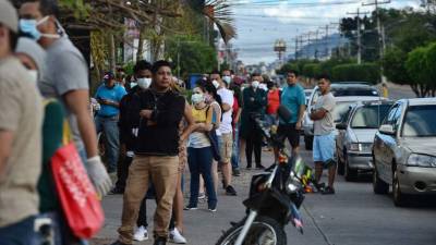 People queue outside a supermarket during a break of the curfew imposed by the government against the spread of the new coronavirus, in Tegucigalpa, on March 19, 2020. - Authorities have confirmed 12 cases of the new coronavirus in Honduras. (Photo by ORLANDO SIERRA / AFP)
