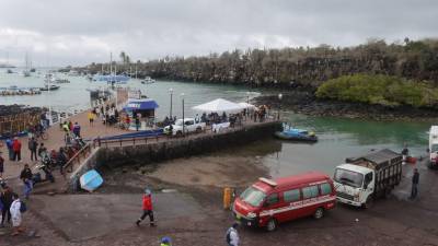 Bomberos y personal de la Marina llegan con un cuerpo recuperado del mar en Puerto Ayora en la Isla Santa Cruz, Islas Galápagos.