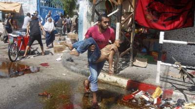 Un hombre corre con un niño herido tras un ataque israelí ayer en Gaza. La OnU alertó de un desastre sanitario en la zona.