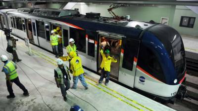 A woman wearing a face mask goes down an escalator at the Chamartin Station in Madrid on April 13, 2020 as some companies were set to resume operations at the end of a two-weeks halt of all non-essential activity amid a national lockdown to stop the spread of the COVID-19 coronavirus. - The death toll from the coronavirus pandemic has slowed in some of the worst-hit countries, with Spain readying to reopen parts of its economy as governments grapple with a once-in-a-century recession. (Photo by PIERRE-PHILIPPE MARCOU / AFP)