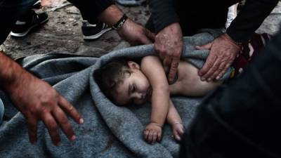 Paramédicos intentan reanimar a una bebé después de que la embarcación en la que viajaba junto a su familia naufragara en el mar Mediterráneo. Al menos siete personas, entre ellas cinco niños, murieron ahogados.
