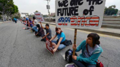LOS ANGELES, CA - JUNE 15: Student Milca Calymayor (R), 18-years-old, blocks a a street around the Los Angeles Federal Building during a demonstration by immigrant student for an end to deportations and urge relief by governmental agencies for those in deportation proceedings on June 15, 2012 in Los Angeles, California. In a policy change, the Obama administration said it will stop deporting young illegal immigrants who entered the United States as children if they meet certain requirements. (Photo by Kevork Djansezian/Getty Images)