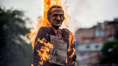 Los chavistas quemaron muñecos del 'Obama iscariote' como parte de la tradicional quema de Judas en Caracas.