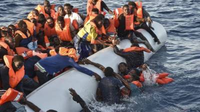Migrantes luchan por subir a un bote en las aguas del Mediterráneo frente a las costas de Libia. Foto: AFP/Andreas Solaro