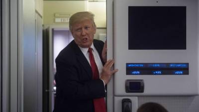TOPSHOT - US President Donald Trump speaks to reporters aboard Air Force One on March 15, 2017. / AFP PHOTO / NICHOLAS KAMM