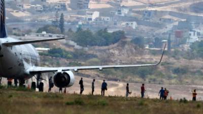 Some 136 Honduran migrants descend from a plane at the Toncontin International Airport, in Tegucigalpa, on April 25, 2020 upon their arrival deported from Mexico and sent to quarentine amid the Covid-19 pandemic. (Photo by ORLANDO SIERRA / AFP)