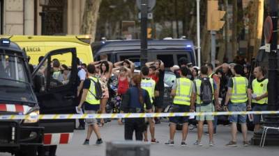 La policía española escolta a los turistas escondidos en restaurantes y bares tras el atropello masivo en las Ramblas. AFP.