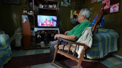 Los hondureños siguieron por televisión la transmisión del Domingo de Ramos. Foto: AFP