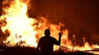 Un hombre frente al incendio forestal en El Hatillo. Foto: AFP