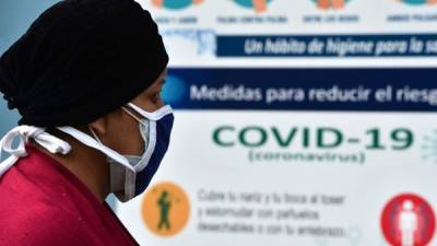 A woman wears a face mask against the spread of the new coronavirus as she queues to enter the Honduran Social Security Institute (IHSS) in Tegucigalpa on April 13, 2020. - 393 cases of COVID-19 and 25 deaths were reported in Honduras so far. (Photo by ORLANDO SIERRA / AFP)