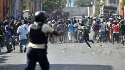 Manifestantes huyen cuando la policía haitiana abre fuego, durante los enfrentamientos, en el centro de Puerto Príncipe. AFP