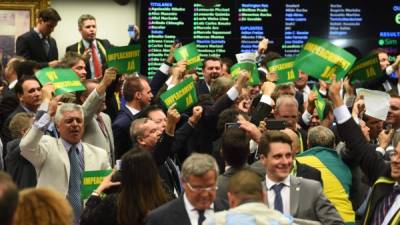 Miembros de la comisión especial celebran después de la votación afavor del juicio político contra Dilma Rousseff. Foto: AFP