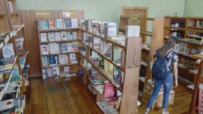 Una joven busca una obra literaria en la librería Atenea.
