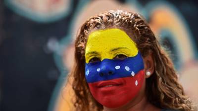 Una activista opositora venezolana luce la bandera de su país pintada en el rostro. Como ella, miles han participado en casi un mes de protestas en Venezuela.