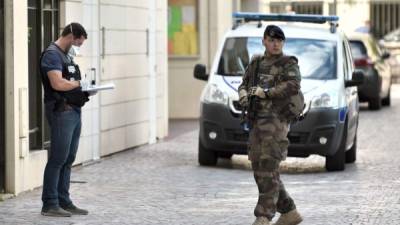 Un soldado francés armado patrulla junto a un oficial de policía forense cerca del sitio donde un coche se estrelló contra los soldados en Levallois-Perret, fuera de París. AFP