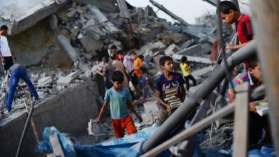 Niños palestinos buscan objetos en una mezquita destruida por los bombardeos israelíes.