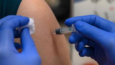 A woman receives a dose of the Sinopharm Covid-19 coronavirus vaccine at the Mount Elizabeth hospital vaccine centre in Singapore on September 7, 2021. (Photo by Roslan Rahman / AFP)