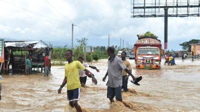 Las personas caminan por las inundadas calles de Leogane, Haití.