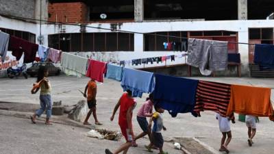 Niños caminan en el refugio Jehova Gire, un edificio a medio hacer de la judicatura en el barrio de Petare, Caracas. AFP