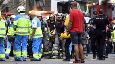 Bomberos atienden a uno de los heridos en el derrumbe de un edificio en Madrid./AFP