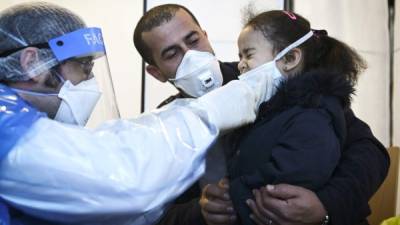 Personal médico realiza prueba de coronavirus a una pequeña. Foto: AFP/Referencia