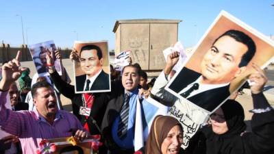 Partidario del expresidente Hosni Mubarak de Egipto se encuentra fuera de la academia de policía en El Cairo durante el juicio el 29 de noviembre de 2014.