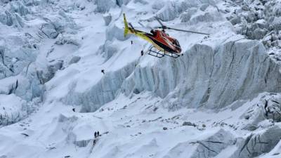 Imagen referencial de un helicóptero sobrevolando una montaña en Nepal.