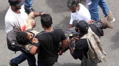 Los manifestantes llevan a un hombre herido durante una protesta que exige la renuncia del presidente de Sri Lanka, Gotabaya Rajapaksa.