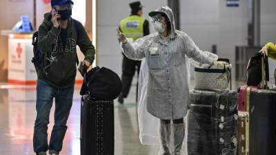 Pasajeros en el aeropuerto de Shanghái se protegen con mascarillas. Foto: AFP