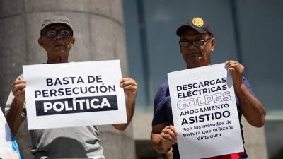 magen de archivo de personas que sostienen carteles durante una manifestación frente a la sede de la ONU en Caracas.