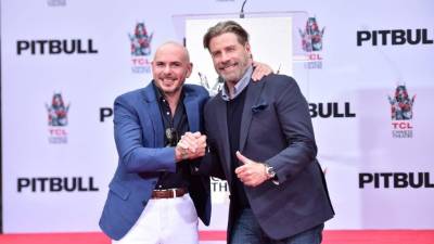 Armando 'Pitbull' Pérez acudió a la ceremonia acompañado del actor John Travolta. AFP
