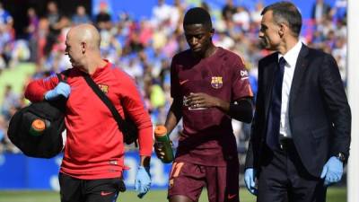 Barcelona's forward from France Ousmane Dembele (C) walks with the team's doctor during the Spanish league football match Getafe CF vs FC Barcelona at the Col. Alfonso Perez stadium in Getafe on September 16, 2017. / AFP PHOTO / PIERRE-PHILIPPE MARCOU