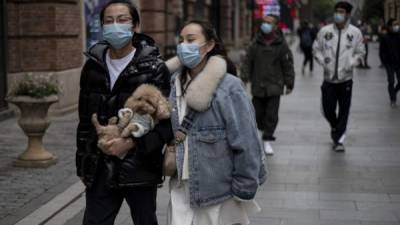 Personas caminan por las calles de Wuhan protegidas con una mascarilla. Foto: AFP