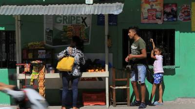 Una mujer compra por una calle de Tegucigalpa.