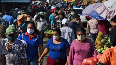 People wear face masks against the spread of the new coronavirus at a market in Tegucigalpa on April 8, 2020. - 312 cases of COVID-19 were reported in Honduras, with 22 deaths. (Photo by ORLANDO SIERRA / AFP)