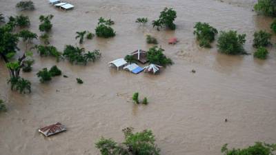 Aerial view of the flooded municipality of Choloma, department of Cortes, Honduras, following the overflowing of the Chamelecon river after the passage of Hurricane Iota, seen on November 19, 2020. - Iota's death toll rose to 38 on Wednesday after the year's biggest Atlantic storm unleashed mudslides, tore apart buildings and left thousands homeless across Central America, revisiting areas devastated by another hurricane just two weeks ago. (Photo by Orlando SIERRA / AFP)