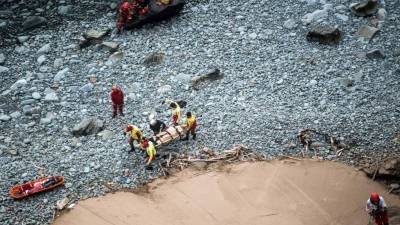 Rescatistas transportan uno de los cuerpos recuperados del lugar del accidente.