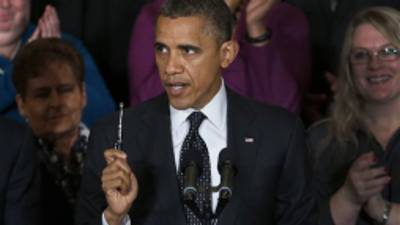 President Barack Obama holds up a pen as he speaks about the economy and the deficit, Friday, Nov. 9, 2012, in the East Room of the White House in Washington. (AP Photo/Carolyn Kaster)