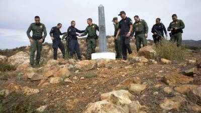 Unos agentes de la Patrulla Fronteriza y sus homólogos de la Policía Federal Mexicana se saludan durante un encuentro informal en las montañas de Otay, al este de San Diego, California.