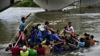 Migrantes hondureños que participan en la caravana a los EEUU cruzan el río Suchiate, frontera natural entre Guatemala y México, en una balsa improvisada en Ciudad Tecún, Uman, Guatemala, hoy 20 de octubre. AFP