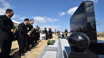 La gente ofrece sus respetos ante el monumento conmemorativo del tsunami de 2011.