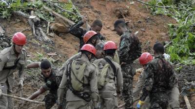 Bomberos, soldados del ejército brasileño y voluntarios trabajan hoy, en el área de un deslizamiento de tierra provocado por fuertes lluvias en el barrio Jardim Monteverde de la ciudad de Jaboatão dos Guararapes (Brasil).
