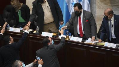 Los diputados Jorge Cálix, y Luis Redondo se saludan en el Congreso Nacional.