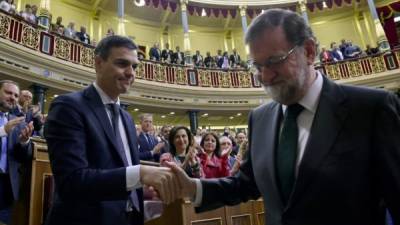 El nuevo primer ministro de España, Pedro Sánchez (L), estrecha la mano del primer ministro de España, Mariano Rajoy (R), tras una votación sobre una moción de censura en la Cámara Baja del Parlamento español en Madrid.