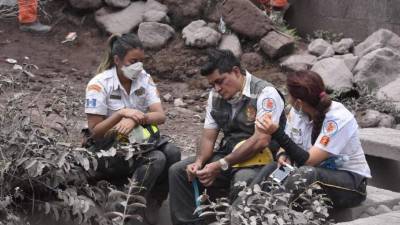 Volunteer firefighters search for victims of Sunday's Fuego Volcano eruption in Alotenango, a municipality in Sacatepequez Department, southwest of Guatemala City on June 6, 2018.New explosions boomed from Guatemala's fearsome Fuego volcano on Wednesday, unleashing fresh torrents of molten mud and ash down slopes where officials said 75 people had been killed and 200 were still missing. / AFP PHOTO / ORLANDO ESTRADA